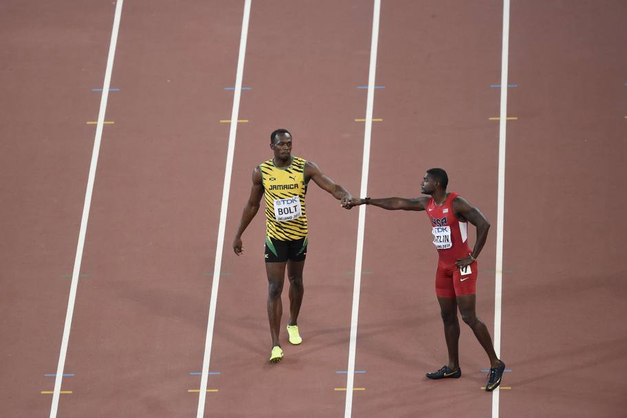 Il saluto tra i protagonisti dei 100 metri di atletica ai Mondiali di Pechino: Usain Bolt e Justin Gatlin. Vincer il giamaicano per un centesimo di secondo (Afp)